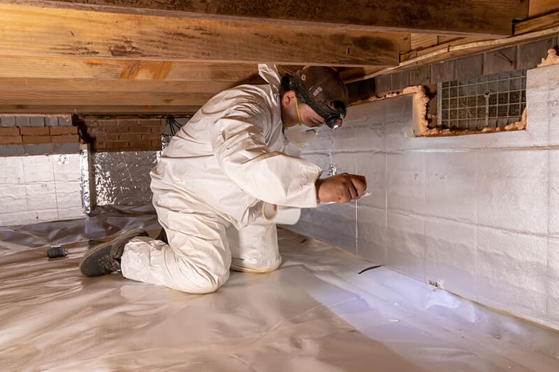Triangle Reconstruction technician at work in a crawl space